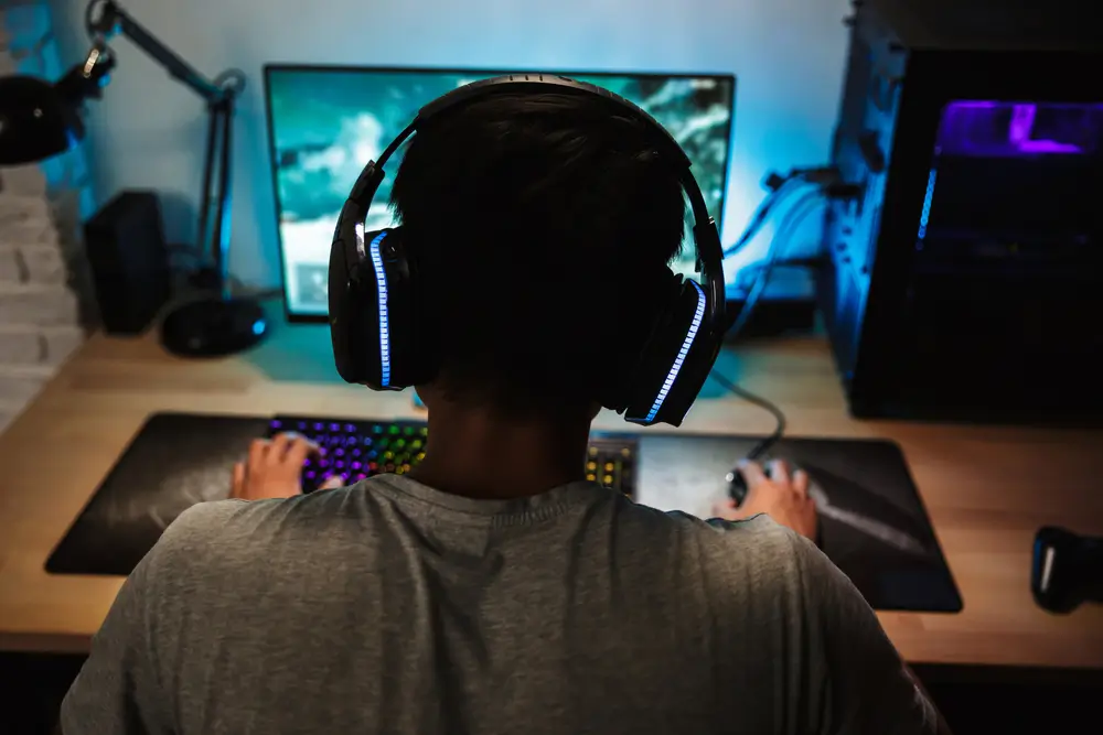 A guy playing video games with Starlink connection